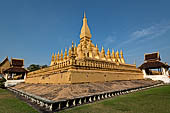 Vientiane, Laos - Surrounded by a cluster of pointed minor stupas the huge Pha That Luang shined under the warm light of the sunset.  